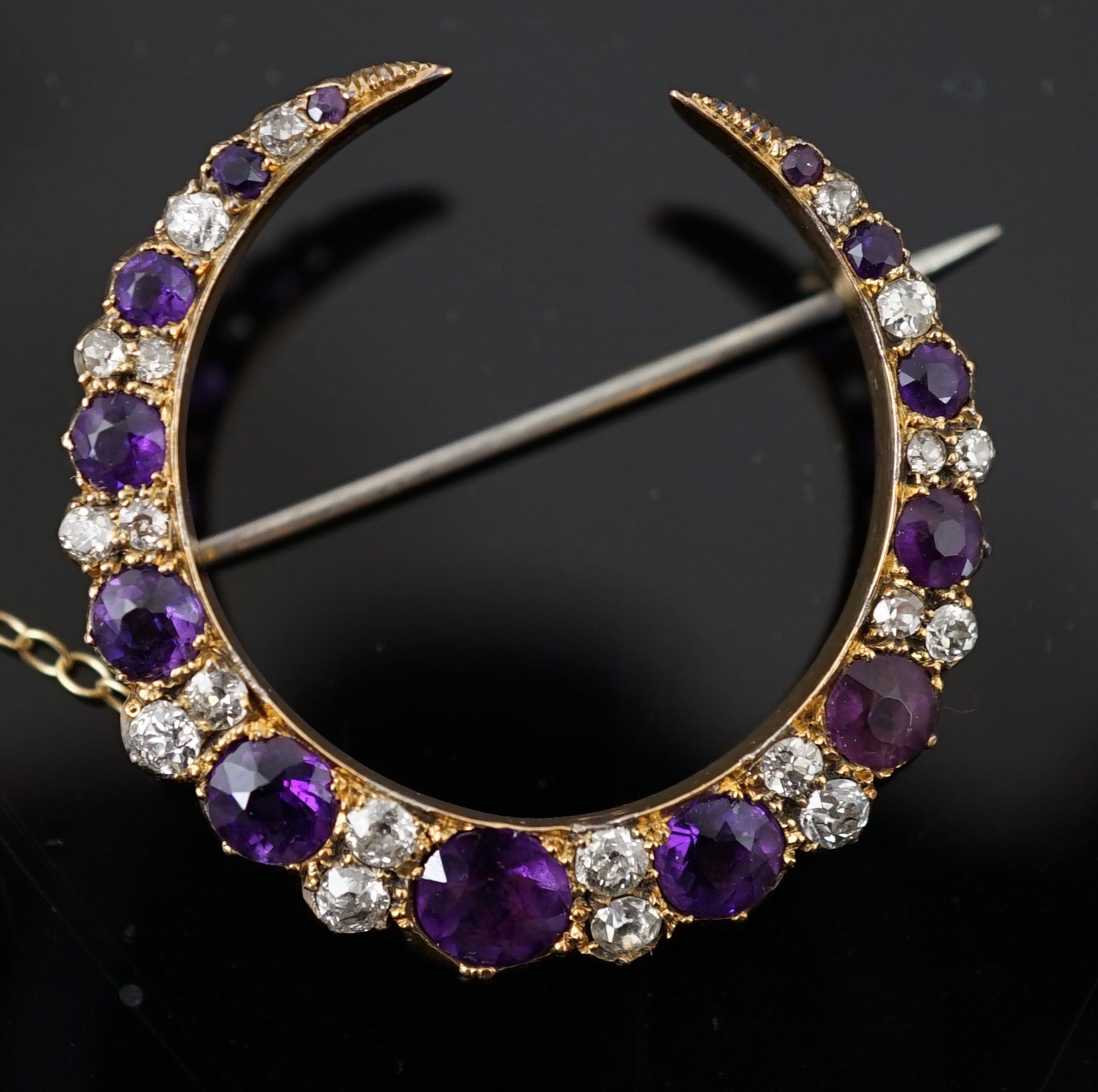 A late Victorian gold, graduated amethyst and diamond cluster set crescent brooch